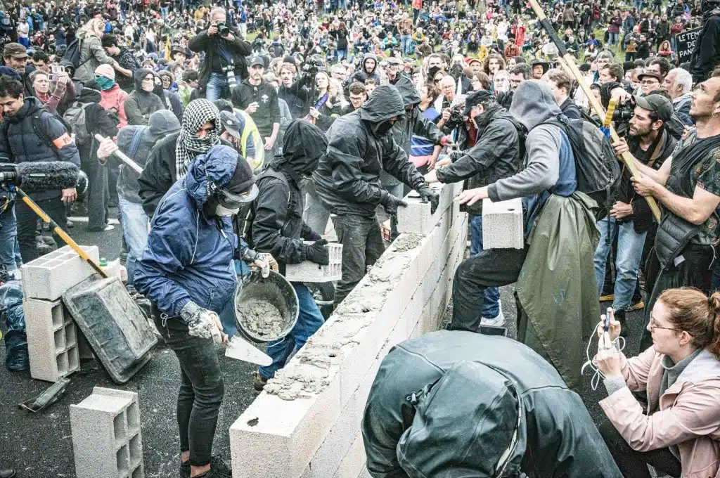 Des militant·es construisent un mur sur la nationale Toulouse-Castre pendant la manifestation du 22 avril 2023 contre l'A69.