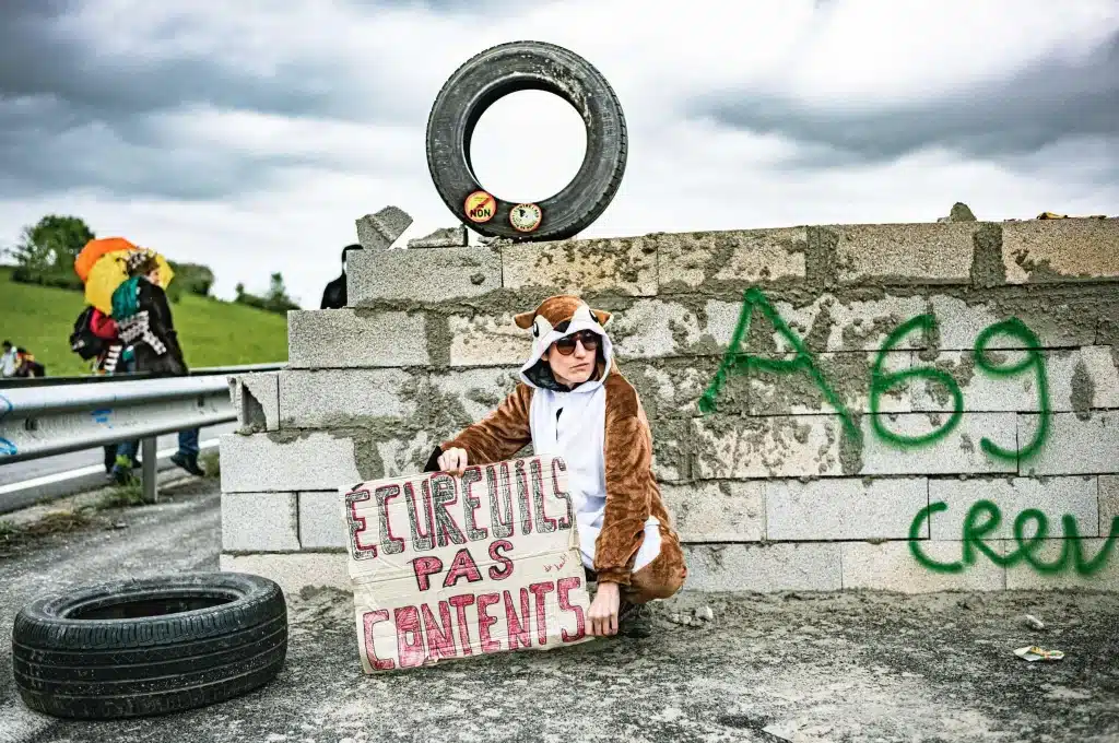 Une manifestante devant le mur construit en travers de la nationale Toulouse-Castres le 22 avril 2023 contre l'A69.